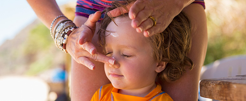Person putting sunscreen on child.