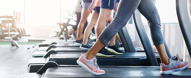 People walking on treadmills at a health club.